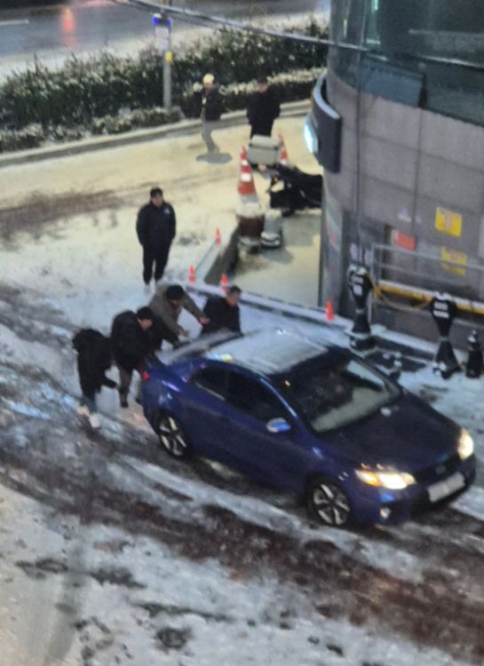 지난 4일 서울 관악구 신림역 인근에서 폭설로 주행에 어려움을 겪는 차량을 시민들이 밀고있다./쓰레드