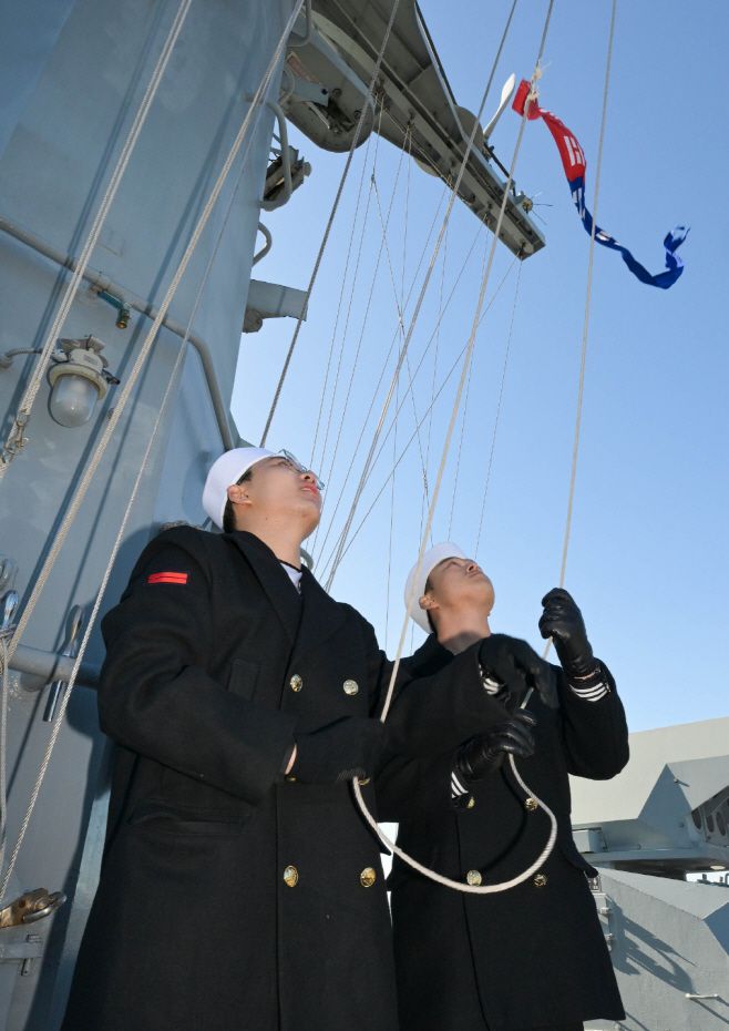 광명함 장병들이 26일 진해 해군기지에서 열린 광명함(PCC) 전역식에서 함정 마스트에 걸린 취역기를 강하하고 있다. /해군