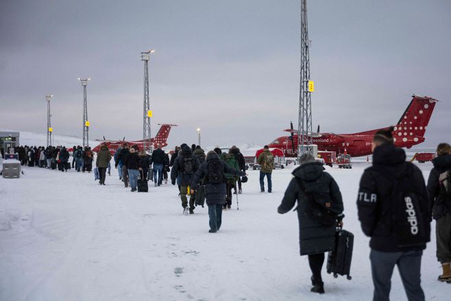승객들이 19일(현지시간) 덴마크 코펜하겐에 도착한 에어그린란드에서 내려 활주로를 끌어가고 있다./AFP·연합