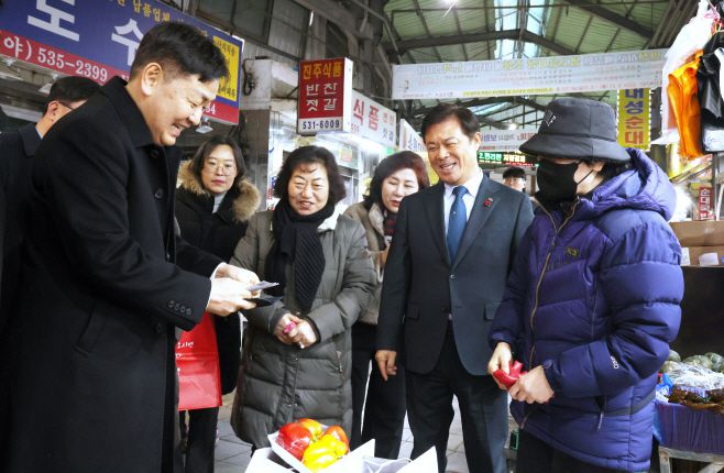 김관영 전북도지사(왼쪽)가 이학수 정읍시장(오른쪽 두번째)과 함께 정읍 샘고을 시장을 방문해 상품을 구입하면서 상인과 환하게 웃으며 대화하고 있다. /정읍시