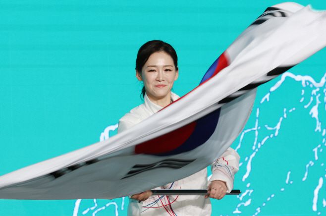 22일 송파구 올림픽파크텔에서 열린 2026 밀라노 동계올림픽 선수단 결단식에서 유승민 대한체육회장으로부터 단기를 건네받은 이수경 선수단장이 태극기를 흔들고 있다./ 연합