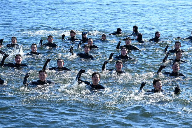 22일 경남 창원 진해군항에서 진행된 혹한기 내한훈련에서 해군 해난구조전대(SSU) 대원들이 바다에 떠오른 채 군가를 제창하고 있다. /해군