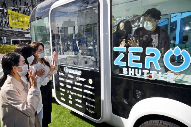 시민들이 제로 셔틀버스를 살펴보고 있습니다.