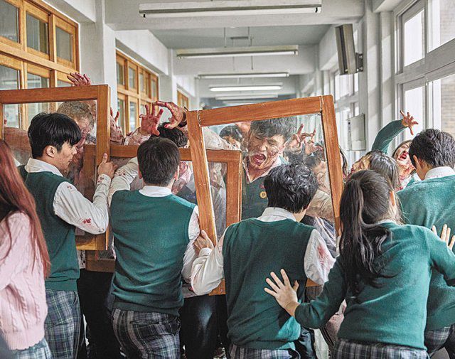 ‘지금 우리 학교는’에서 주인공 학생들이 복도에서 창문을 들고 좀비 떼를 막고 있다. 넷플릭스 제공