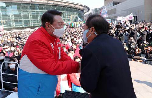 윤석열 국민의힘 대선 후보가 제20대 대통령 공식 선거운동 시작일인 15일 오후 대구 동구 동대구역광장에서 연설대에 올라 홍준표 의원과 두 손을 맞잡고 있다. ⓒ News1