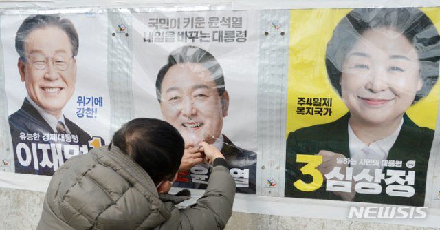 선거관리위원회 측이 훼손된 벽보를 보수하고 있다. 뉴시스