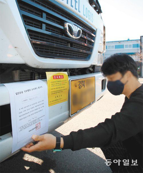‘운송거부 행위 조사 통지서’ 부착 8일 오후 경북 포항시 제철동 도로에 세워진 화물연대 소속 화물차에 대해  국토교통부와 포항시 직원이 집단운송거부 행위 조사개시 통지서와 주차 단속 예고장을 함께 부착하고 있다. 포항=전영한 기자  scoopjyh@donga.com