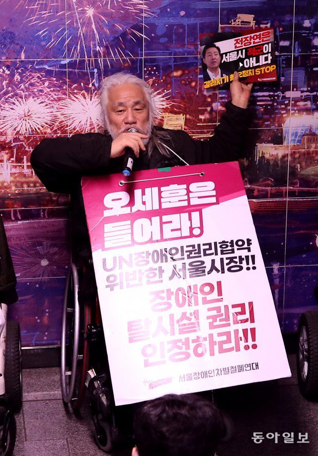 박경석 전국장애인차별철폐연대(전장연) 공동상임대표가 23일 오전 서울 지하철 1호선 시청역 승강장에서 가진 기자회견에서 ‘전장연은 서울시의 적군이 아니다’라는 인쇄물을 벽에 붙이고 있다.  양회성 기자 yohan@donga.com