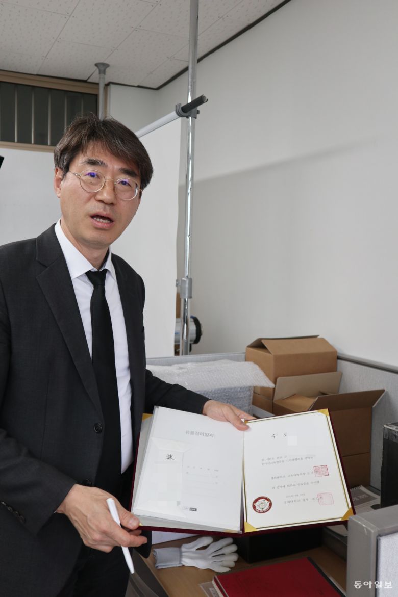 그의 사무실 한편에 놓인 유품들. 유족들이 박스에 넣어 보내면 일일이 열어보고 촬영하고 분석하는 과정을 거친다.  부산=서영아 기자 sya@donga.com