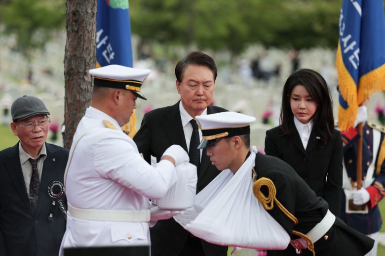 윤석열 대통령과 김건희 여사가 6일 오전 서울 동작구 국립서울현충원 52묘역에서 6·25전쟁 전사자 故 김봉학 육군 일병의 유해를 안장하는 ‘호국의 형제’ 안장식에 참석해 영현병이 유해를 받는 모습을 지켜보고 있다.     고 김봉학 일병의 유해는 동생인 고 김성학 육군 일병 묘역에 합동 안장됐다. 형제는 6·25전쟁에 참전한 지 73년 만에 유해로 상봉했다. 2023.6.6 대통령실 제공