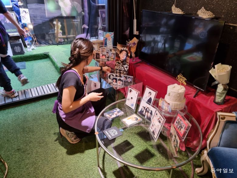 2일 오후 서울 용산구 하이브 사옥 인근의 한 카페에서 직원 김예서 씨(21)가 BTS 멤버들의 사진이 담긴 액자를 정리하고 있다. 주현우 기자 woojoo@donga.com