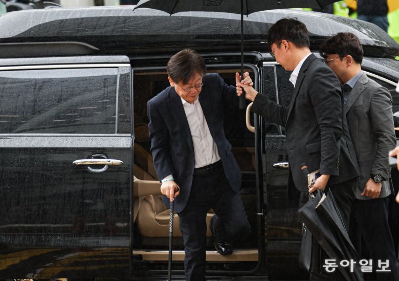 26일 이재명 대표가 지팡이를 짚으며 차량에서 내린 뒤 우산을 건네받고 있다. 이한결 기자 always@donga.com