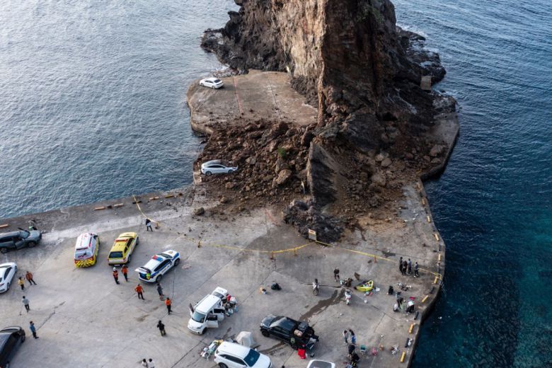 사고 발생 후 출동한 소방대원들이 현장을 수습하는 가운데 차량 한 대가 낙석지대를 빠져나오지  못하고 있다. 울릉군 제공