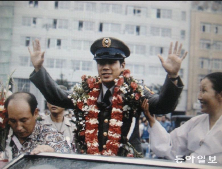 아놀드 테일러와의 WBA 밴텀급 챔피언타이틀 전이 끝나고 서울에서 슈퍼스타가 된 당시 육군 일병 홍수환의 귀국 축하 카퍼레이드가 열렸다.  홍수환이 시민들에게 손을 흔들고 있다. 오른쪽 옆은 모친 황농선 여사.  홍수환 제공