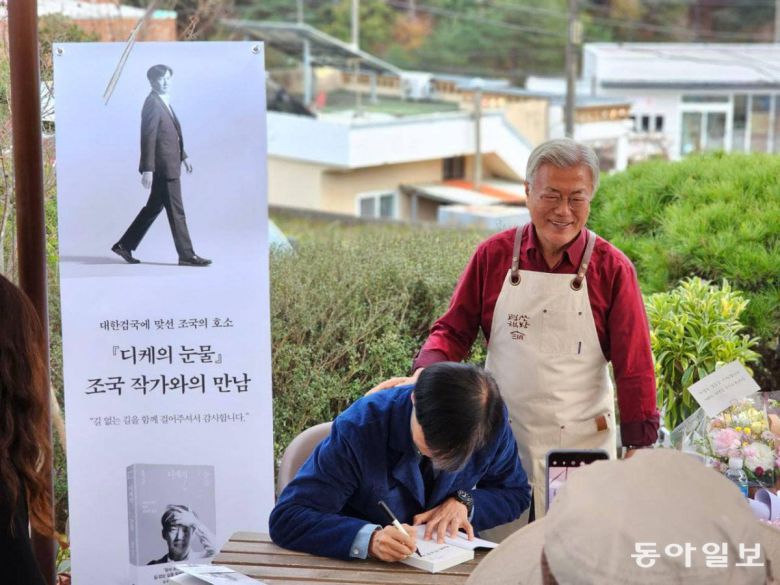 11월 9일 문재인 전 대통령이 운영하는 경남 양산시 평산책방에서 ‘작가와의 만남’을 진행한 조국 전 법무부 장관이 자신의 책 ‘디케의 눈물’에 사인을 하는 모습. 조 전 장관 뒤에서 문 전 대통령이 활짝 웃고 있다. 조 전 장관 페이스북