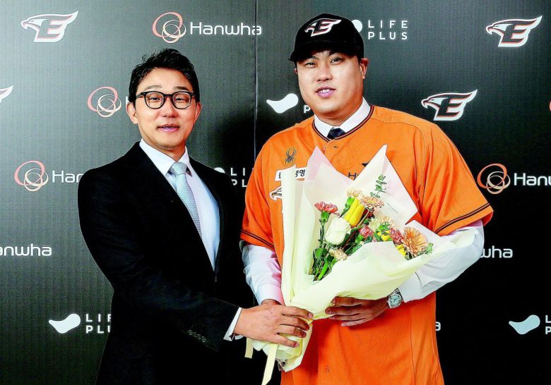 12년 만에 한국프로야구 친정팀 한화 유니폼을 다시 입은 류현진(오른쪽)이 22일 구단과 8년 총액 170억 원에 계약을 마친 뒤  박찬혁 대표이사에게서 꽃다발을 전달받았다. ‘8년 170억 원’은 한국 프로야구 역대 최대 규모 계약이다. 한화 제공