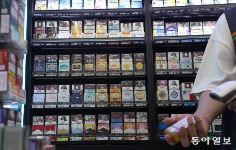 28일(현지 시간) 네덜란드 헤이그의 한 슈퍼마켓에선 진열대 아래 하얀 수납장을 열어야 안에 있는 담배를 볼 수 있다. 평소에는  수납장을 닫아 아동·청소년에게 담배가 노출되지 않는다(위쪽 사진). 반면 서울의 한 편의점에선 계산대 뒤에 진열돼 방문자 누구나  쉽게 담배를 접할 수 있다. 헤이그=조유라 jyr0101@donga.com·변영욱 기자 cut@donga.com