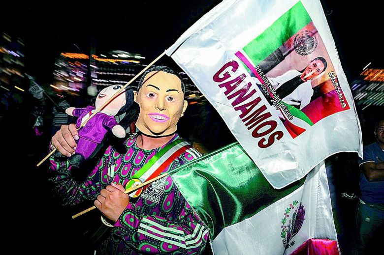 손가락 보이며 투표 인증… 지지자들 환호 2일 멕시코 수도 멕시코시티에서 집권당 ‘모레나’ 소속 클라우디아 셰인바움 후보가 투표를 마친 후 승리를 자신하며 인주가 묻은  오른쪽 엄지손가락을 들어 보이고 있다(위 사진). 그의 승리가 기정사실화한 같은 날 밤 그의 지지자들이 헌정 사상 최초의 여성  대통령 탄생을 반기며 멕시코시티 도심으로 몰려나왔다. 얼굴에 가면을 쓴 채 셰인바움 후보의 사진이 든 깃발을 흔들고 있는 지지자.  멕시코시티=AP 뉴시스