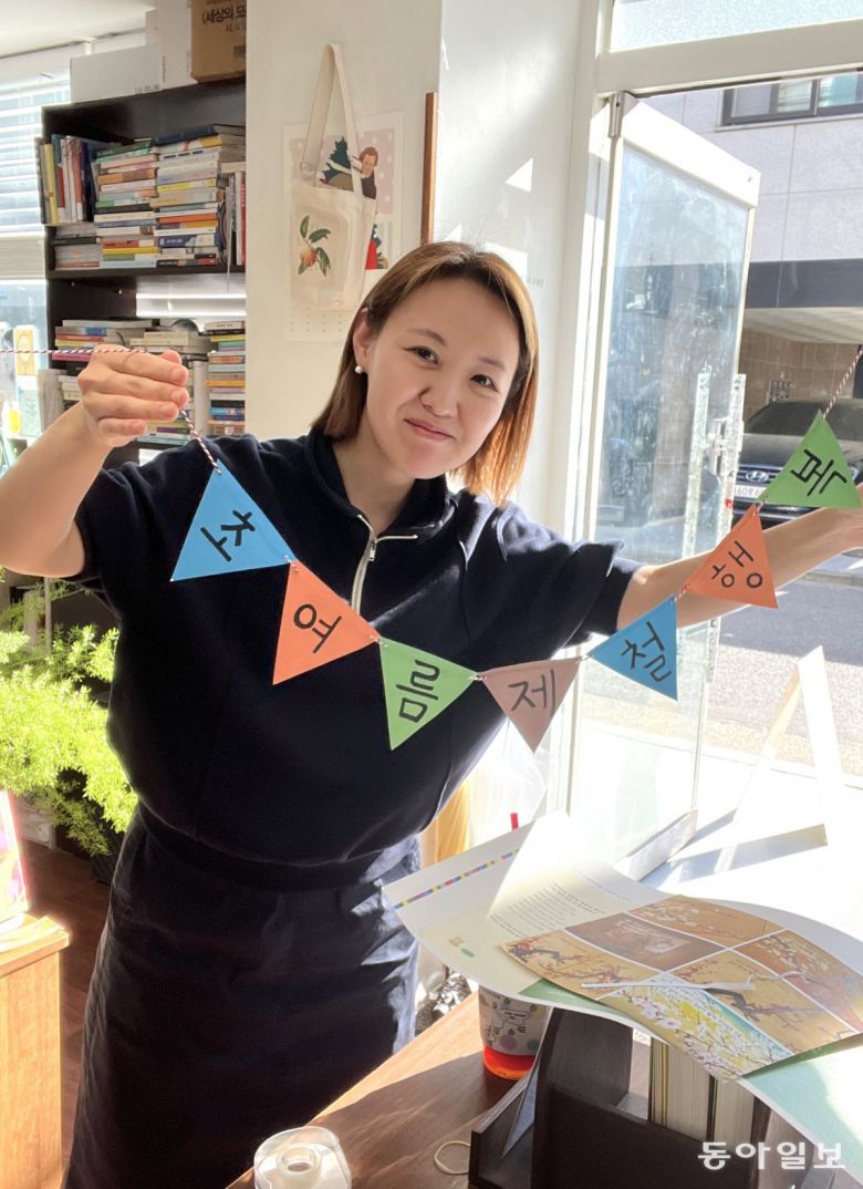 ‘제철 행복’ 편집자인 허문선 인플루엔셜 편집3팀장이 서울 마포구의 동네책방 겸 작업실 ‘작업책방 씀’에서 올해 5월 열린 ‘작가의 책상’ 전에 설치할 문구를 들고 있다. 김신지 작가의 ‘제철 행복’이 소개됐다.   허문선 팀장 제공