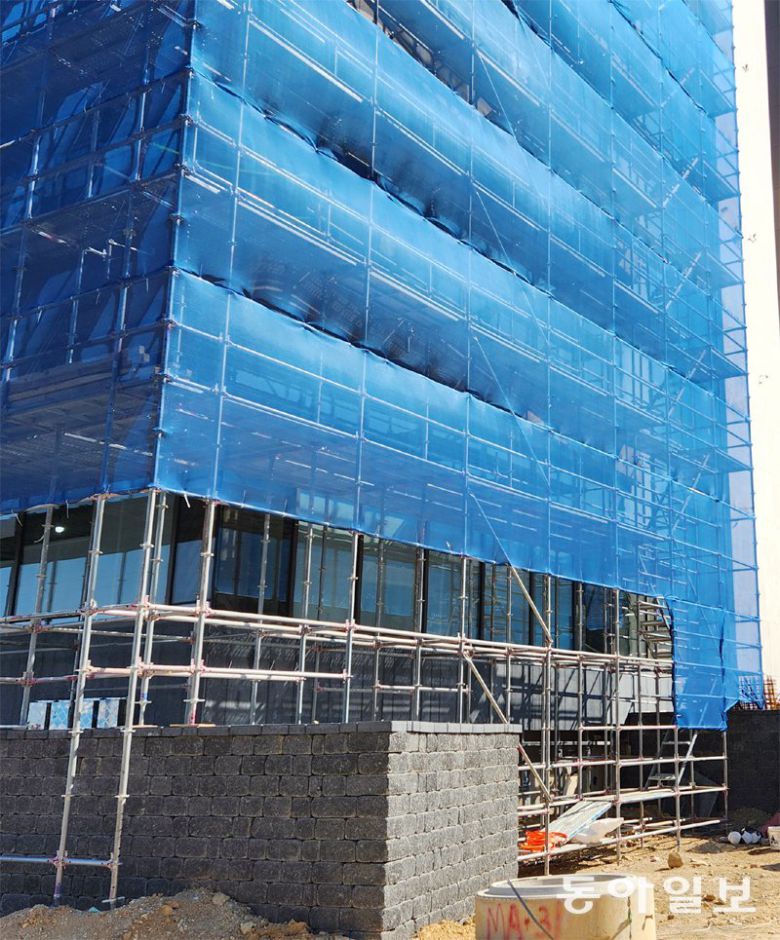 19일 부산 기장군 ‘반얀트리 해운대 부산’ 리조트 C동 외벽에 철제 임시가설물(비계)과 안전 그물망이 설치돼 있다. 김화영 기자 run@donga.com