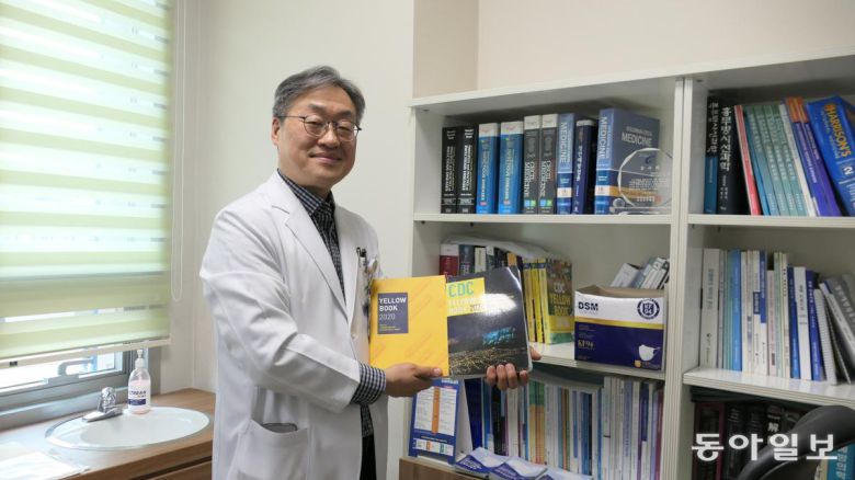 김진용 인천광역시의료원 감염내과 과장이 5일 진료실에서 미국 질병통제관리센터(CDC) 엘로북과 최근 질병관리청에서 번역한 2020년 판 CDC 옐로북을 들고 있다. 김 과장은 신종 감염병 관련 자료를 대부분 직접 해외 관련 기관 사이트 등을 뒤져 찾아내 공부했다. 인천=민동용 기자 mindy@donga.com
