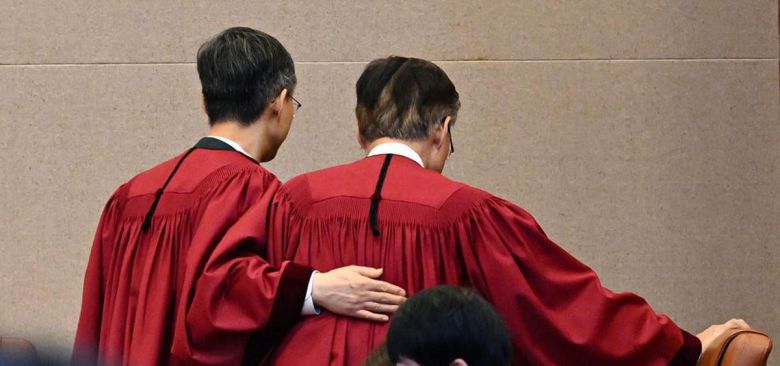 차기 대행 등 두드려주는 文대행 문형배 헌법재판소장 권한대행(왼쪽)이 4일 오전 서울 종로구 헌재 대심판정에서 윤석열 전 대통령 탄핵심판 인용 결정을 선고한 뒤 퇴정하며 김형두 재판관의 등을 두드리고 있다. 문 권한대행이 18일 퇴임하면 임명일과 연장자 순서에 따라 김 재판관이 헌재소장 권한대행을 맡게 된다. 사진공동취재단