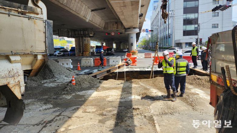 13일 오전 부산 사상구 학장동 한 횡단보도에 가로 5m 세로 3m 깊이 4.5m 크기의 싱크홀이 발생해 부산시 등이 긴급 보수공사를 진행하고 있다. 김화영 기자 run@donga.com