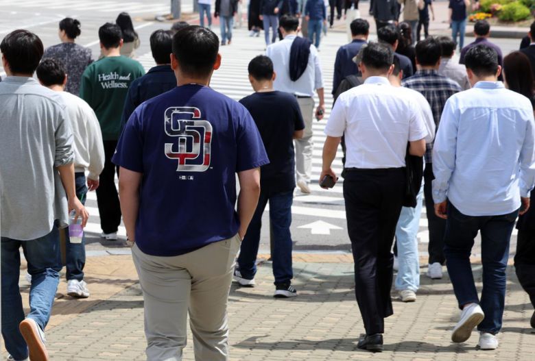 서울의 낮기온이 24도까지 오르며 초여름 날씨를 보인 23일 오후 서울 영등포구 여의도공원 앞에서 반팔을 입은 시민이 이동하고 있다. 2025.04.23 뉴시스
