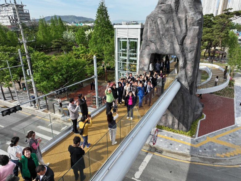 최근 대구 달서구 선돌공원과 선돌마당공원 사이에 놓인 선돌보도교 위에서 방문객들이 촬영용 드론을 향해 손을 흔들고 있다. 달서구 제공