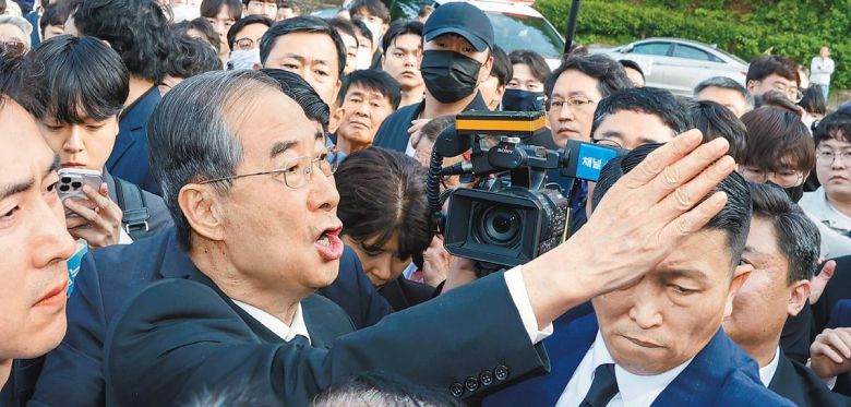 “우리 통합돼야 합니다” 대선 출마를 공식 선언한 한덕수 전 국무총리가 2일 광주 북구 국립5·18민주묘지를 찾았다가 시민단체 관계자 등에게 가로막히자 “저도 호남 사람”이라며 참배를 호소하고 있다. 한 전 총리는 이날 묘역에 들어가지 못하고 민주의문 앞에서 묵념으로 참배를 대신했다. 광주=뉴스1