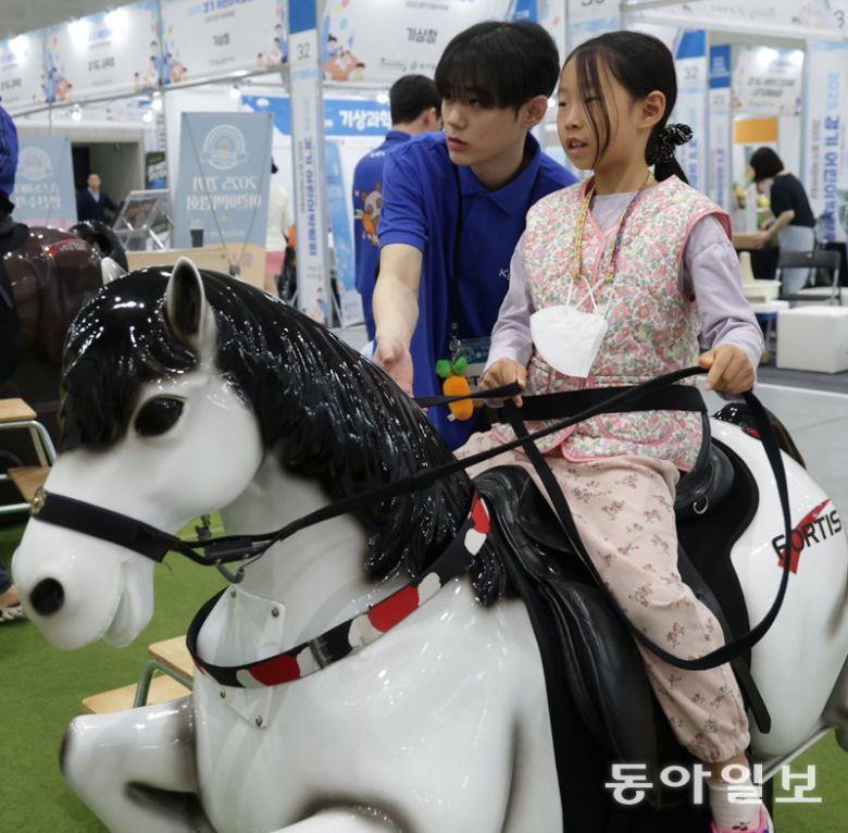 한국마사회가 마련한 기승 시뮬레이터 체험존에서 어린이들이 말의 움직임을 그대로 구현한 기구를 타고 승마를 체험하고 있는 모습. 수원=박형기 기자 oneshot@donga.com