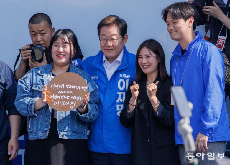 “반도체 강국” 제21대 대통령 선거 공식 선거운동 첫날인 12일 더불어민주당 이재명 대선 후보(가운데)가 경기 화성시 동탄 집중 유세에서 웨이퍼에 ‘세계 1위 반도체 강국 도약!’이라고 적은 뒤 기념 촬영을 하고 있다. 화성=이훈구 기자 ufo@donga.com