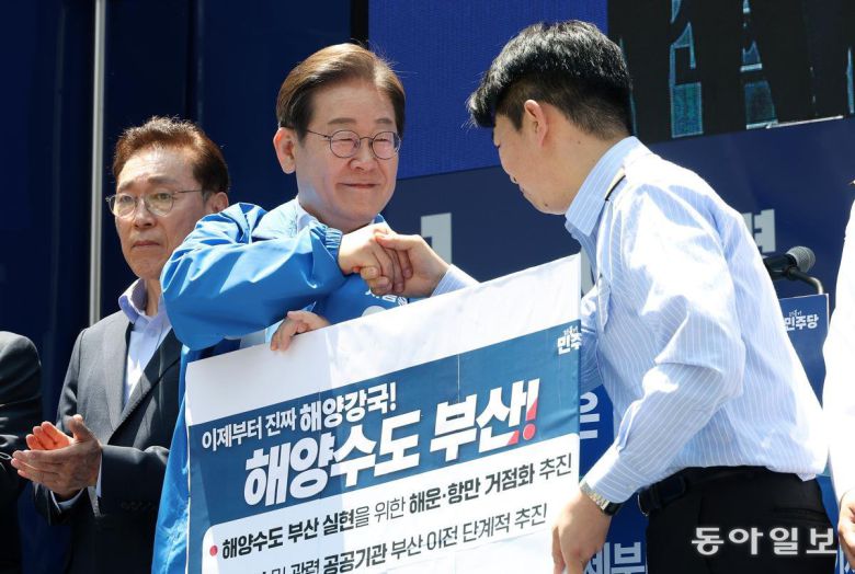 더불어민주당 이재명 대선 후보(왼쪽)가 14일 부산 부산진구 서면 젊음의 거리에서 열린 유세에서 해양수도 부산 협약서에 서명한 뒤 권기흥 에이치라인해운해상직원노조 위원장과 악수하고 있다. 이 후보는 이날 해양수산부와 국내 최대 해운회사 HMM의 부산 이전 등을 약속했다. 부산=이훈구 기자 ufo@donga.com