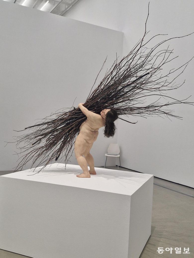 론 뮤익 ‘나뭇가지를 든 여인’(2019)의 뒷모습. 제 몸집보다 큰 나뭇가지를 짊어지느라 안간힘을 쓰고 있는 여자의 모습이다. 이소연 기자 always99@donga.com