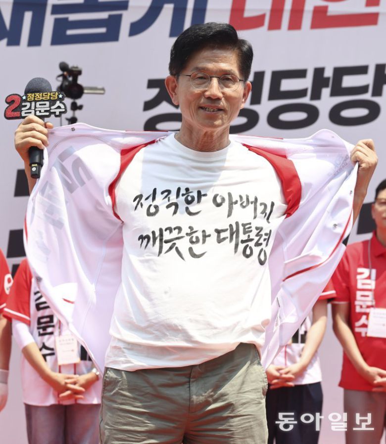 국민의힘 김문수 대선 후보가 1일 서울 강남구 수도권 광역급행철도(GTX) 삼성역 공사장 앞에서 열린 유세에서 더불어민주당 이재명 후보의 방탄조끼를 비판하며 웃옷을 벗고 있다. 김 후보는 ‘정직한 아버지 깨끗한 대통령’ 문구가 적힌 티셔츠를 내보였다. 장승윤 기자 tomato99@donga.com