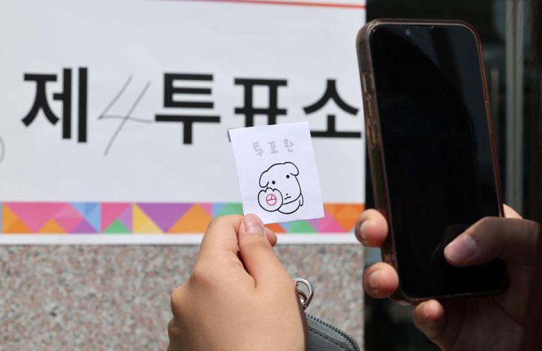 제21대 대통령 선거일인 3일 서울 서대문구 서울창서초등학교에 마련된 신천동 제5투표소를 찾은 유권자가 투표를 마친 후 인증샷을 찍고 있다. 2025.6.3/뉴스1