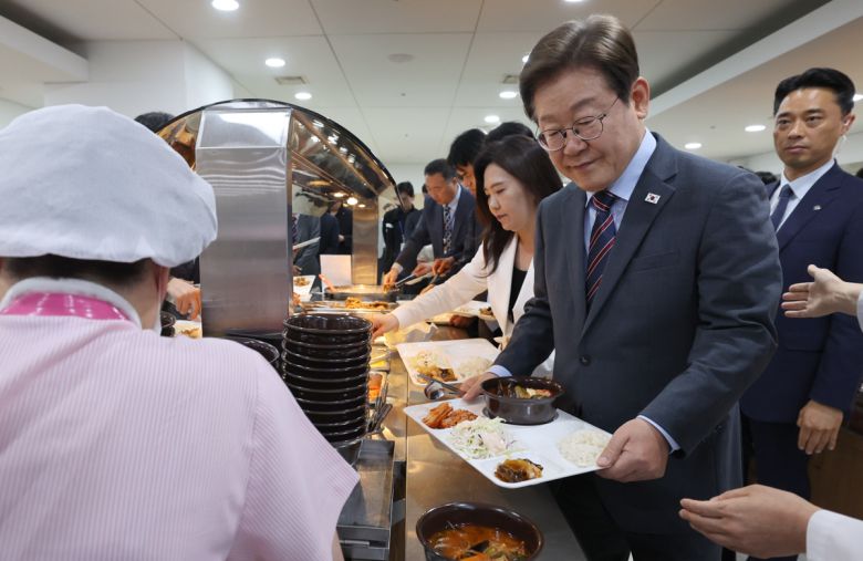 이재명 대통령이 12일 서울 용산 대통령실청사 직원식당에서 사진 및 영상기자들과 오찬을 하기 위해 배식을 하고 있다. 대통령실사진기자단