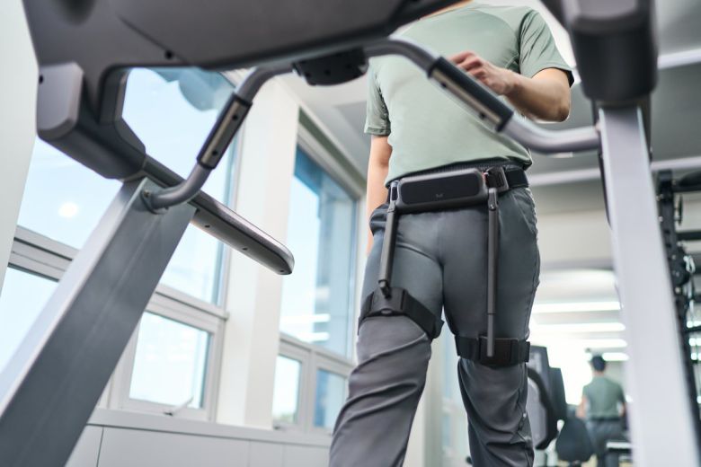 사용자가 ‘윔 S’를 착용한 채 트레드밀 위를 걷고 있다. 실내 보행 환경에서도 기기의 착용감과 운동 보조 기능을 테스트할 수 있다.