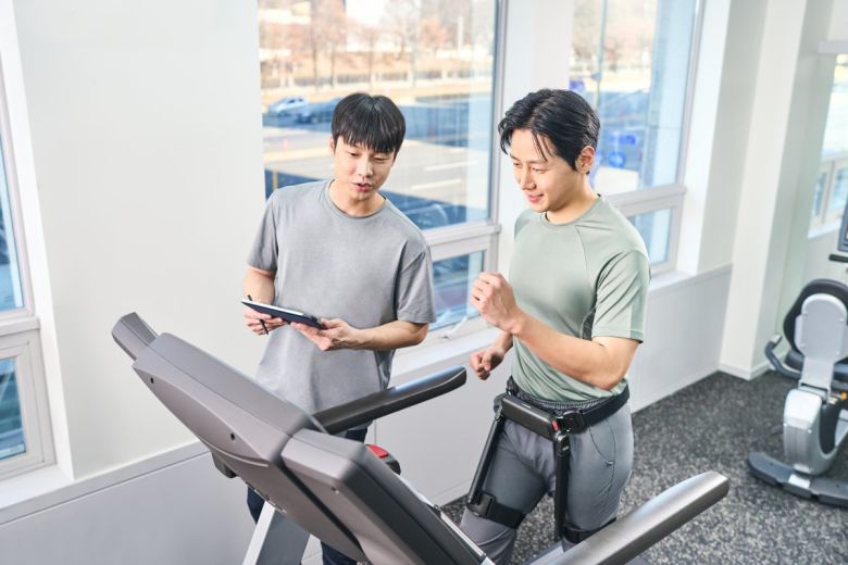 윔 S’를 착용한 사용자가 트레드밀에서 보행 운동을 실시하며 실시간으로 운동 효과를 확인하고 있다.