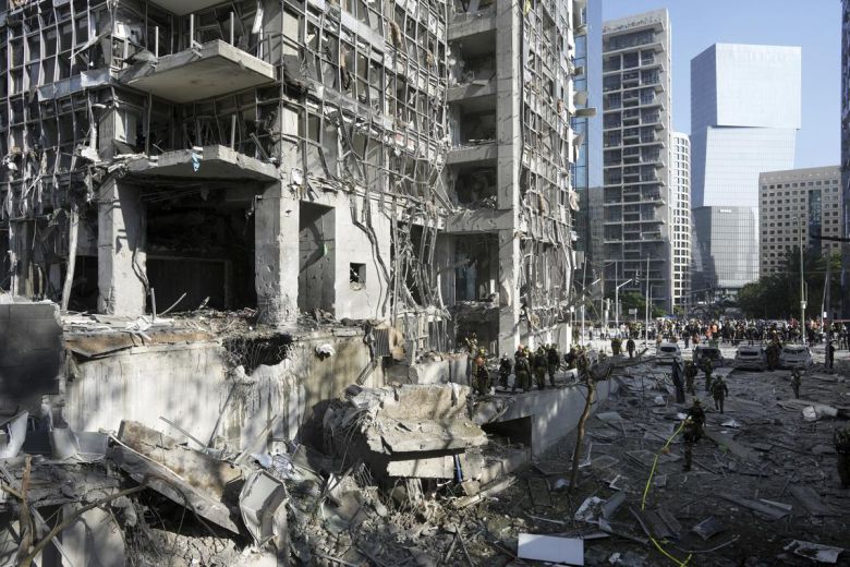 19일(현지 시간) 이스라엘 텔아비브 인근 라마트간에서 구조대와 군 관계자들이 이란의 미사일 직격 현장을 살피고 있다. 2025.06.19.라마트간=AP/뉴시스