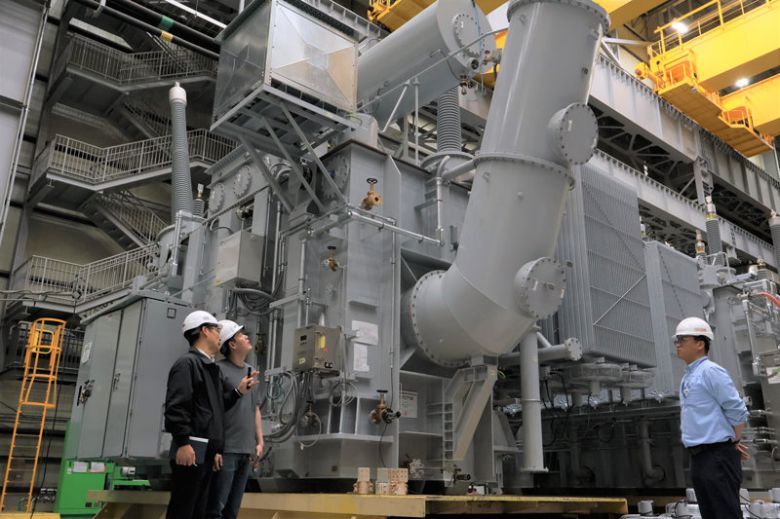 강진호 HD현대일렉트릭 앨라배마 법인장(왼쪽)이 미국 현지 공장에서 만들어진 154kV(킬로볼트)급 대형 변압기에 대해 설명하고 있다. HD현대일렉트릭은 지난해 미국 내 대형 변압기 시장 점유율 15%를 달성하며 1위에 올랐다. HD현대일렉트릭 제공