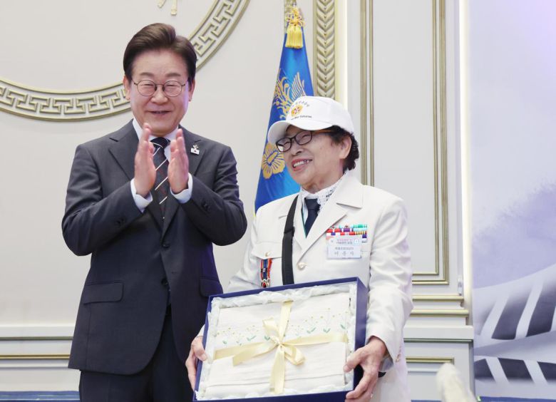 이재명 대통령이 27일 청와대 영빈관에서 열린 ‘호국보훈의 달, 대통령의 초대’ 행사에서 특별초청 대상자인 6·25전쟁 참전유공자 이춘자 참전용사에게 광목이불 선물을 전달 후 박수치고 있다. (대통령실통신사진기자단) 2025.06.27.