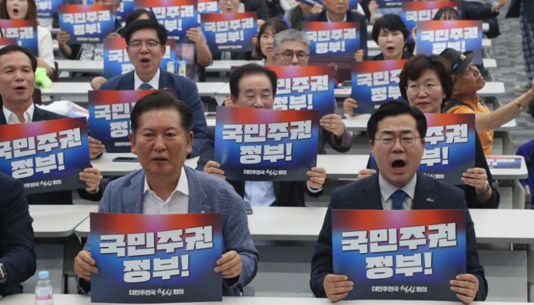 “국민주권 정부” 더불어민주당 대표로 나선 박찬대, 정청래 의원(앞줄 오른쪽부터)이 29일 오후 충북 청주시 오송읍 오스코에서 열린 ‘더민주전국혁신회의 전국대회’에 참석해 ‘국민주권 정부!’라고 적힌 피켓을 들고 있다. 민주당은 권역별 순회경선을 거쳐 8월 2일 경기 고양시 킨텍스에서 전당대회를 열 예정이다. 청주=뉴스1