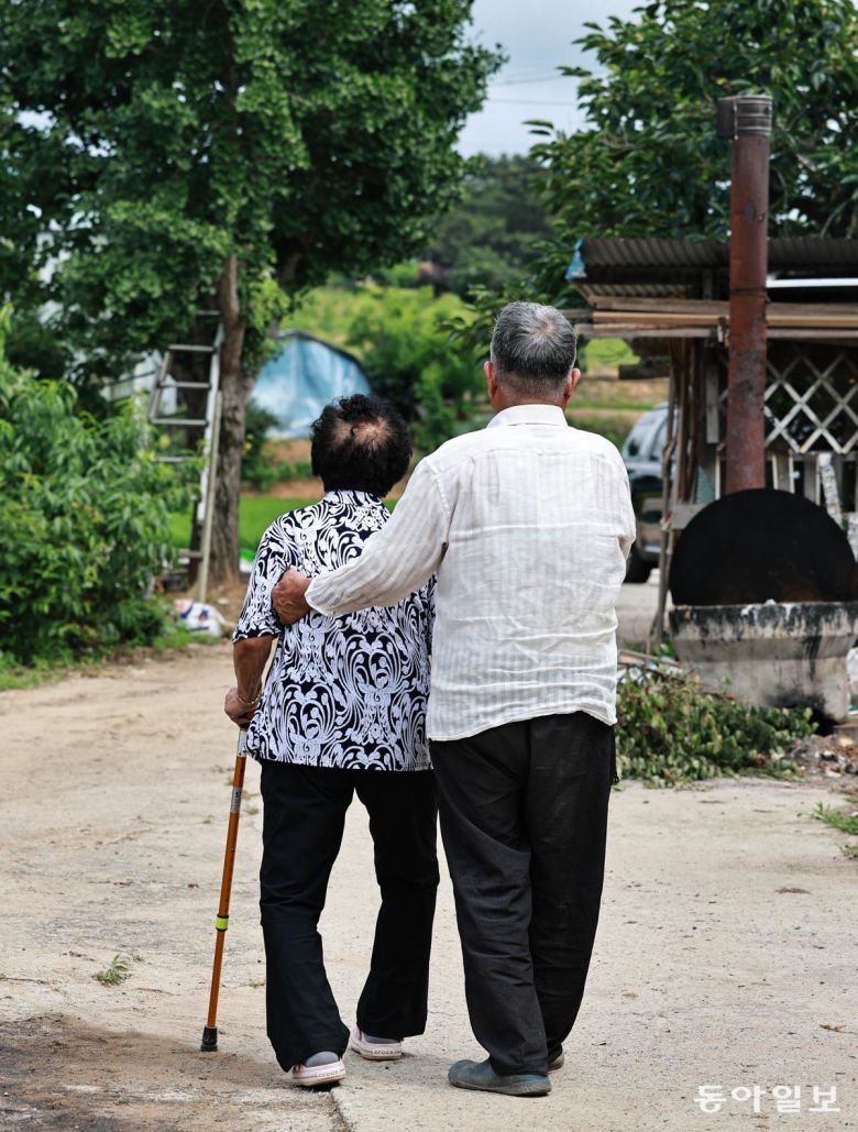 30일 오후 안무춘 씨(오른쪽)가 아내 김옥태 씨를 부축해 함께 동네를 산책하고 있다. 충남 서산시 해미면에 사는 안 씨 부부는 각각 2014년, 2015년 치매 진단을 받았다. 서산=양회성 기자 yohan@donga.com
