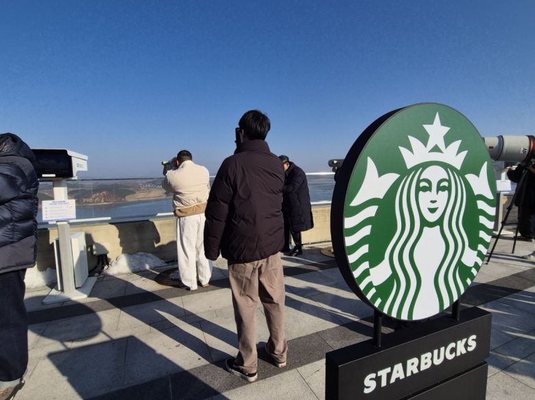 경기 김포시 애기봉평화생태공원 조강전망대에 스타벅스가 문을 열면서 음료를 주문한 방문객들이 망원경으로 북한을 바라보고 있다. 뉴스1