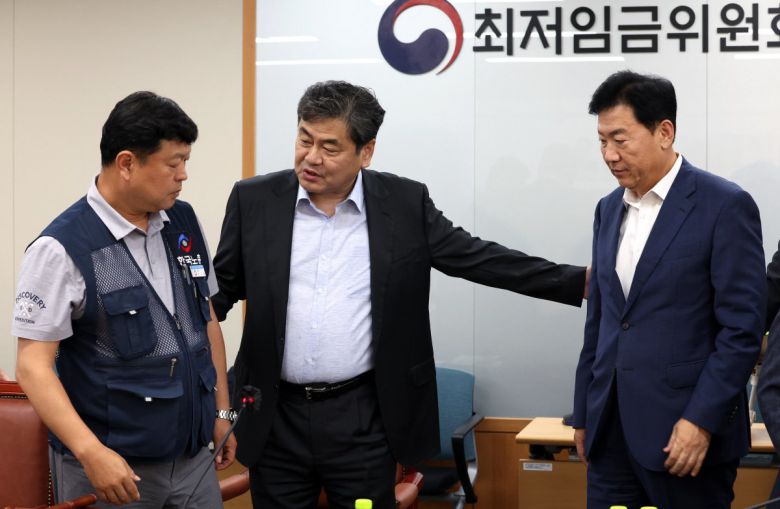 최저임금위원회 이인재 위원장이 지난 10일 밤 세종시 정부세종청사에서 2026년도 적용 최저임금안을 합의로 결정한 뒤 류기정 사용자 위원, 류기섭 근로자 위원과 대화하고 있다. 내년도 최저임금은 1만 320원으로 결정됐다. 2024.07.11.뉴시스