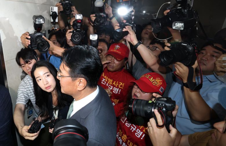 11일 피의자 신분으로 특검에 출석하는 김태효 전 국가안보실 1차장. 주변에서  해병대 예비역연대 회원이 항의를 보내고 있다. 뉴스1