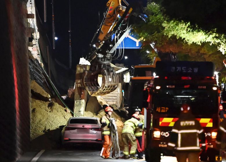 수도권 등 중부지역에 호우주의보가 발효된 16일 오후 경기 오산시 가장교차로 고가도로 옹벽이 무너져 소방관들이 매몰된 차량을 구조작업하고 있다. 2025.07.16 뉴시스