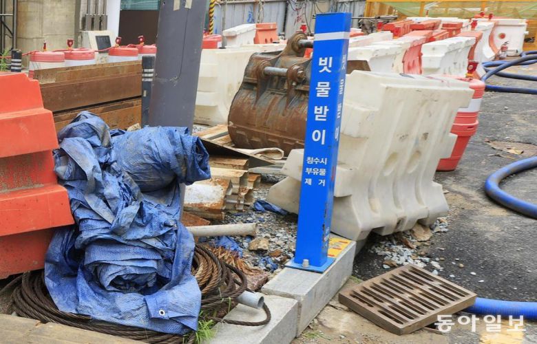 빗물받이 주변에 자재 더미 18일 광주 남구 백운광장 주변 배수구 주변에 쓰레기 봉투와 공사 자재 등이 놓여 있어 침수 위험을 키웠다. 광주=박영철 기자 skyblue@donga.com