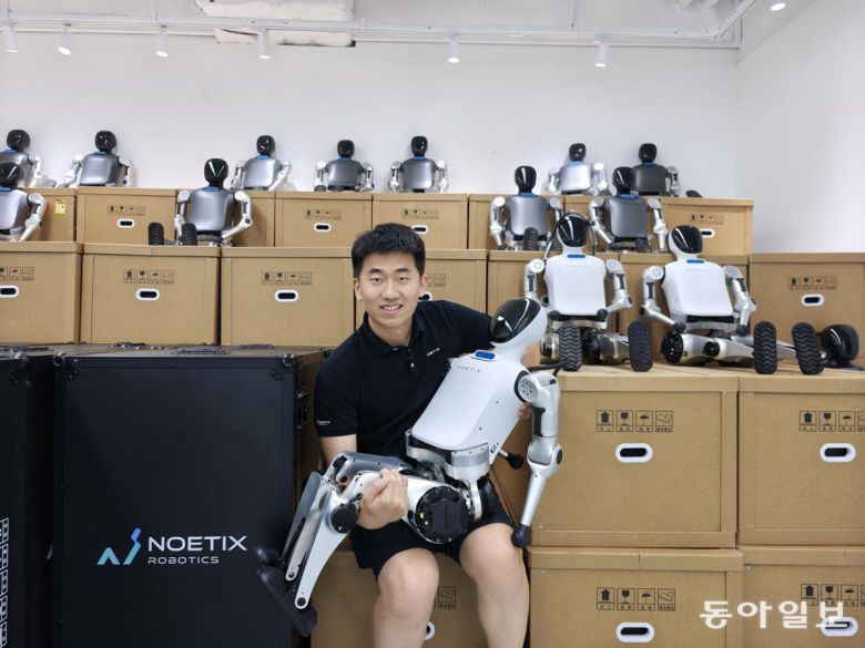 4일 베이징 창핑구 본사에서 휴머노이드 로봇 업체 ‘쑹옌둥리’의 창업자 장저위안이 올 4월 마라톤 대회에서 준우승한 휴머노이드 로봇 N2를 안고 기념촬영하고 있다. 베이징=김철중 특파원 tnf@donga.com